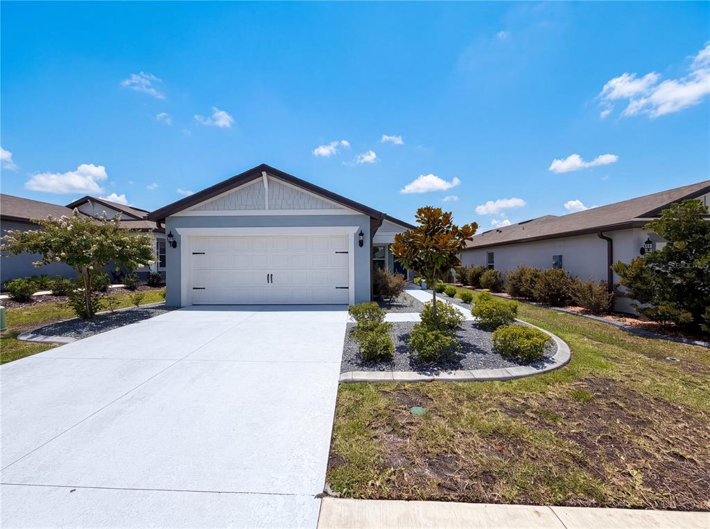 A light blue house with a white garage door and a concrete driveway — 8332 SW 54TH LOOP, OCALA, FL