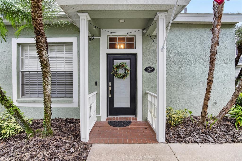 A front entryway features a black door with a wreath, brick flooring, and white columns — 10807 SIERRA VISTA PLACE, TAMPA, FL