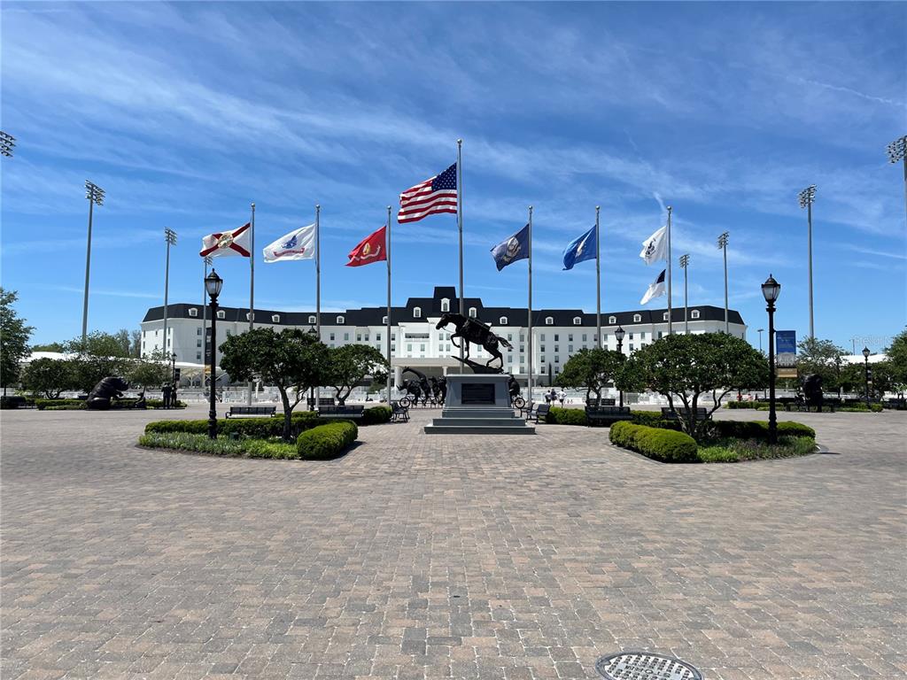 A large building stands behind a central horse statue and several flags on a plaza — Lot 12 W HWY 40, OCALA, FL