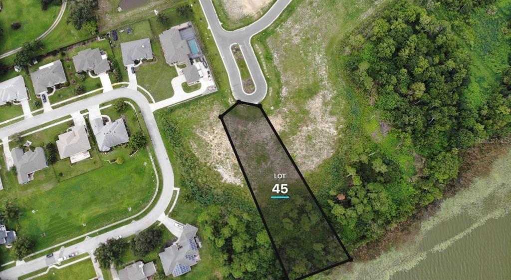 An aerial view shows a vacant residential lot labeled 45 situated next to a lake — 552 WALKER STREET, OAKLAND, FL
