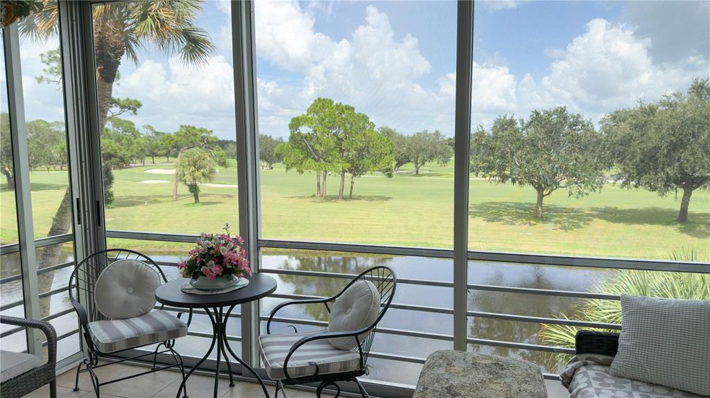 A screened-in patio overlooks a pond and a golf course with scattered trees — 7461 W COUNTRY CLUB DRIVE N UNIT 306, SARASOTA, FL