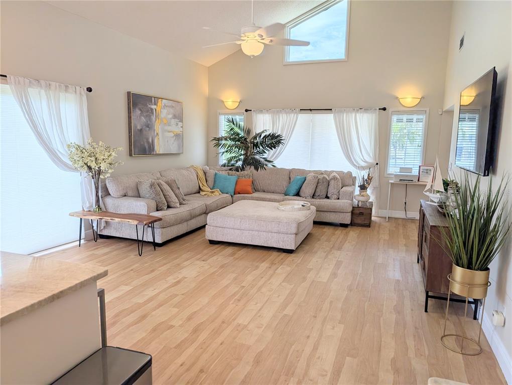 A living room features a large sectional sofa, light wood flooring, and vaulted ceilings — 2934 GULF OF MEXICO DRIVE UNIT 2934, LONGBOAT KEY, FL