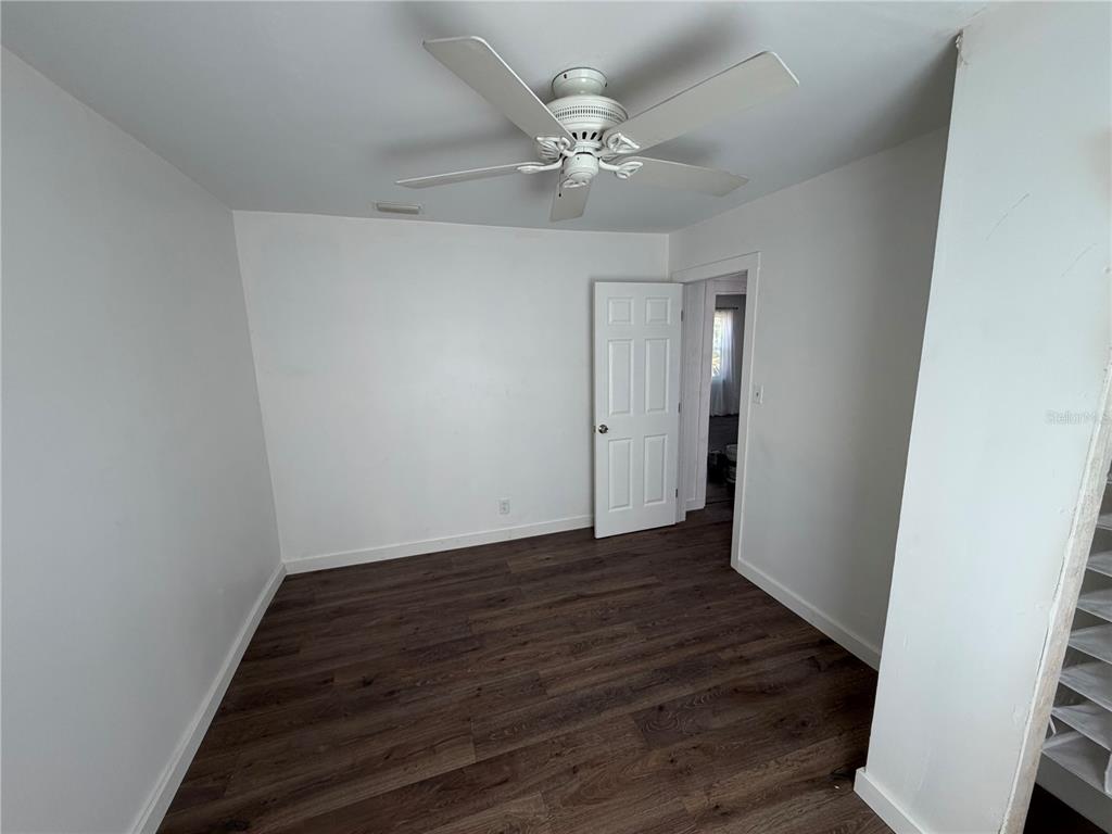 A kitchen with dark cabinets and white countertops opens into a living area with flooring — 911 N 21ST STREET, FORT PIERCE, FL