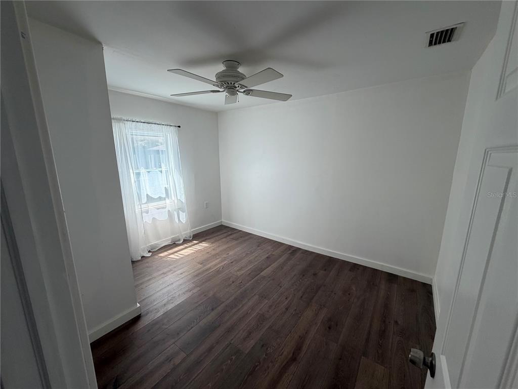 A utility room features wood-look flooring, a water heater, a ladder, and two windows — 911 N 21ST STREET, FORT PIERCE, FL