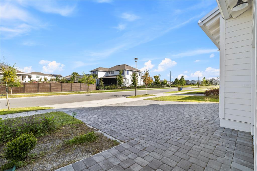 An aerial view of a two-story white house with a paved driveway and solar panels — 6422 TRAILBLAZE BEND, ST CLOUD, FL