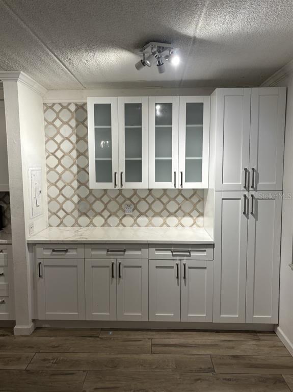 A kitchen area features white shaker cabinets, a marble-look countertop, and a patterned tile backsplash — 109 S OBRIEN STREET UNIT 123, TAMPA, FL
