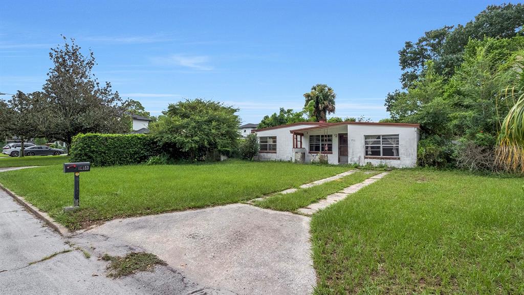 A single-story house with a white exterior, a flat roof, and a concrete driveway — 1416 BORDER DRIVE, WINTER PARK, FL
