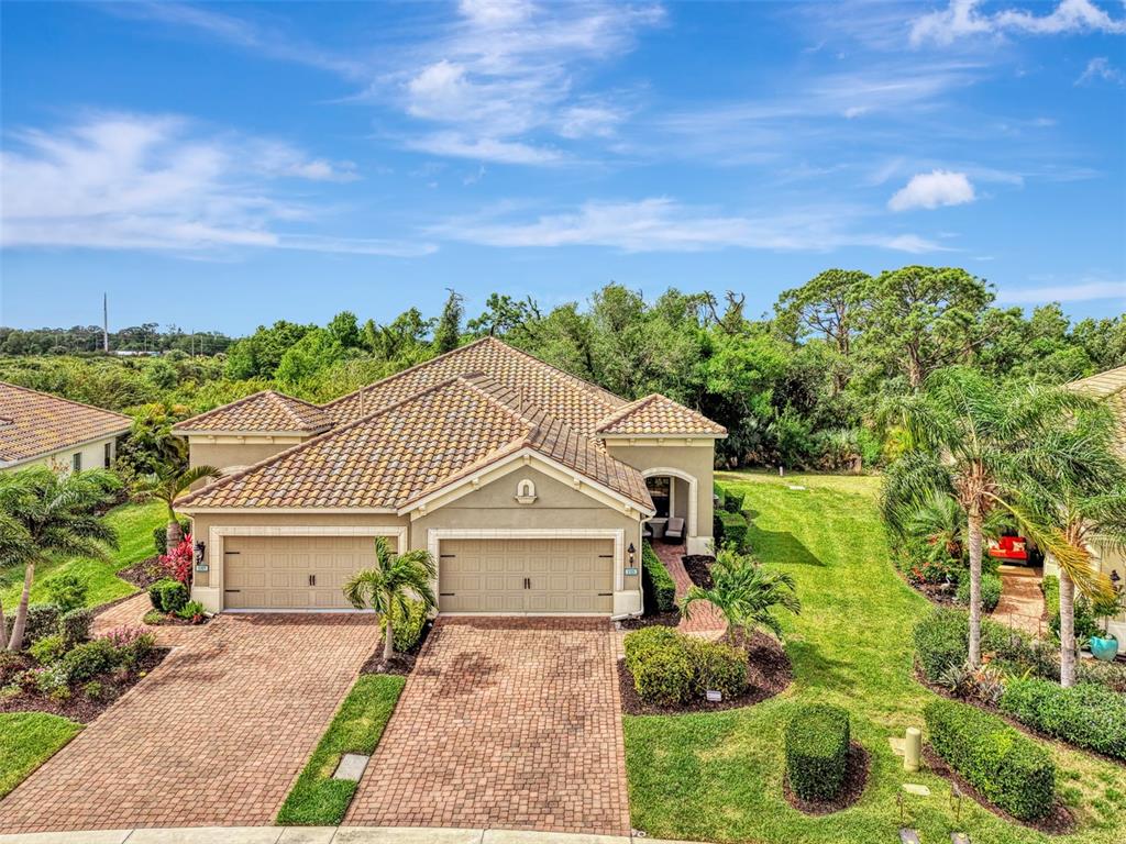 An aerial view of a tan house with a tiled roof and a brick driveway — 1321 BACKSPIN DRIVE, ENGLEWOOD, FL