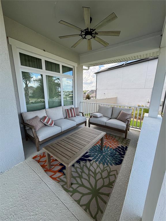 A covered patio features outdoor furniture, a patterned rug, and a ceiling fan — 13186 MAGNOLIA VALLEY DRIVE, CLERMONT, FL