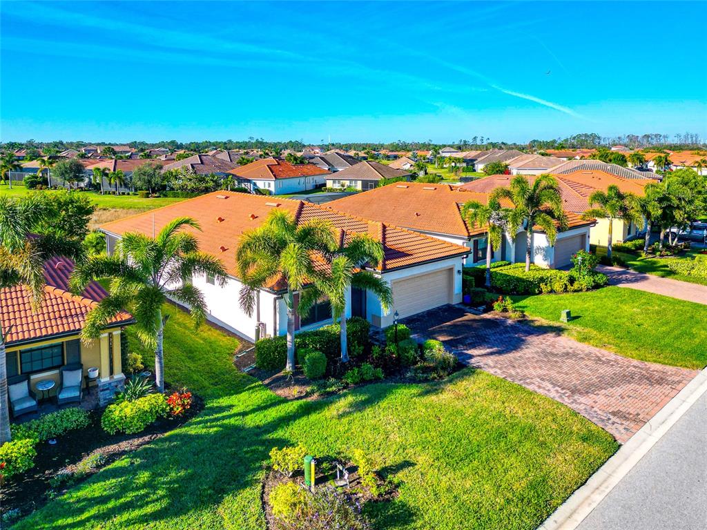 An aerial view shows a suburban house with a tile roof and a brick driveway — 10202 MARBELLA DRIVE, BRADENTON, FL