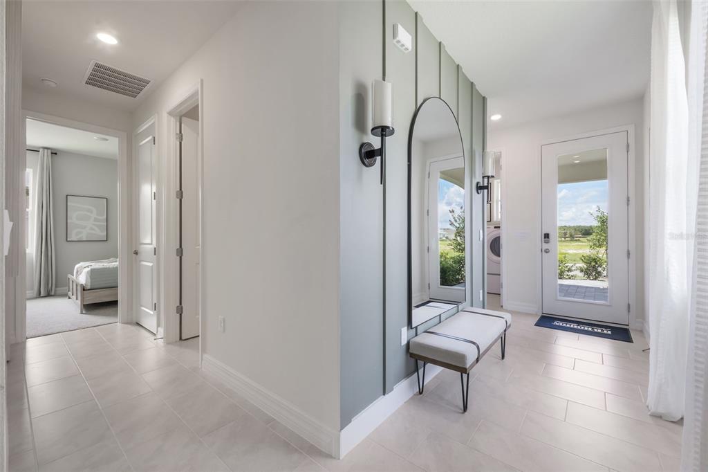 An entryway features a light gray accent wall with board and batten, a mirror, and bench — 3945 KENNEBUNK LOOP, MOUNT DORA, FL