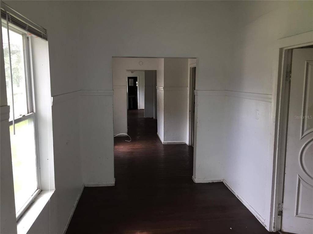 An interior view showing a hallway with dark wood flooring and white walls — 1489 GROTHE STREET, JACKSONVILLE, FL