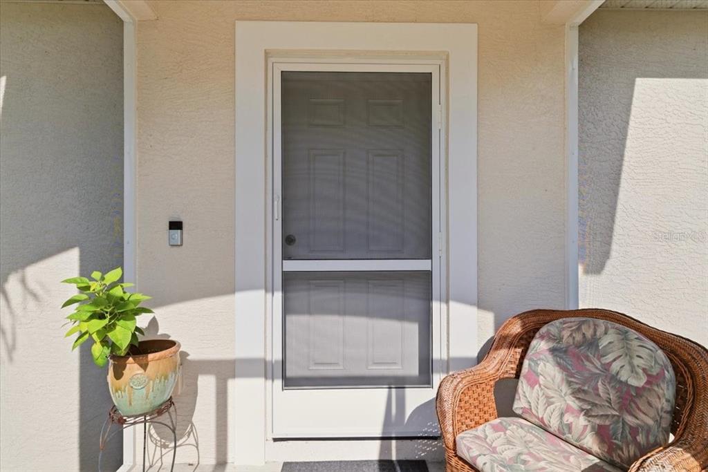 A front entryway features a screen door, a potted plant on a stand, and wicker furniture — 6143 STURGIS STREET, ENGLEWOOD, FL