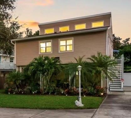 A two-story house with light-colored siding, a front lawn, and a house number sign — 313 CRYSTAL BEACH AVENUE, CRYSTAL BEACH, FL