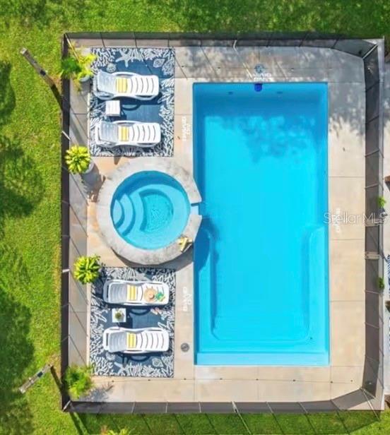 An elevated view of a backyard swimming pool and a circular hot tub with lounge chairs — 313 CRYSTAL BEACH AVENUE, CRYSTAL BEACH, FL