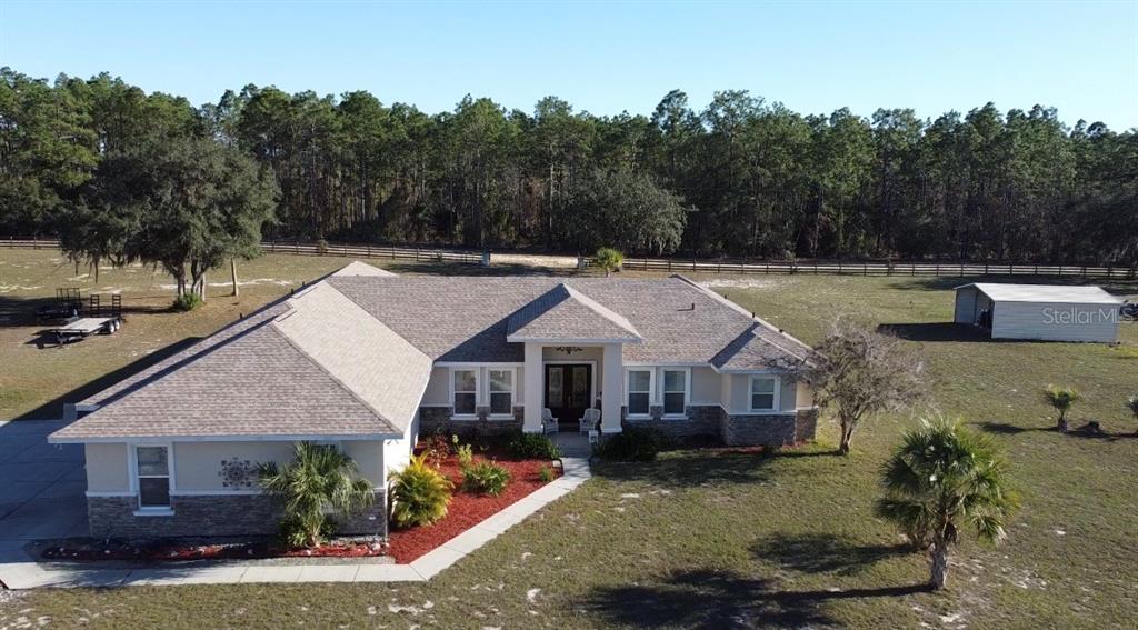 An aerial view shows a house with a pool and outbuildings on a large lot — 6081 W PELL PLACE, DUNNELLON, FL
