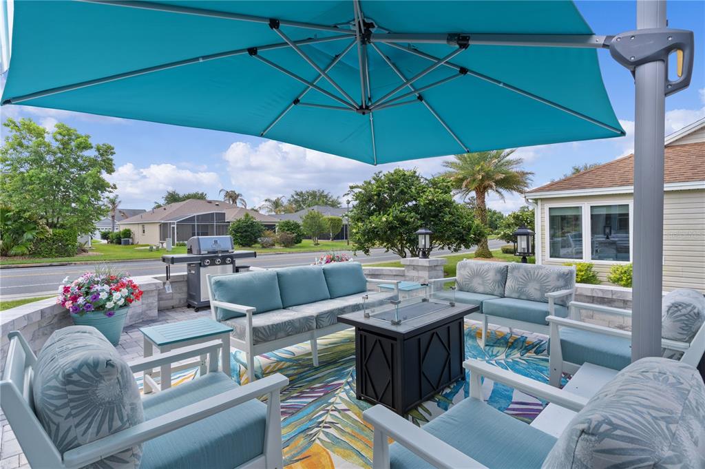 A living room and kitchen bar area with wood flooring, light-colored furniture, and a wine display — 1795 HAGOOD LOOP, THE VILLAGES, FL
