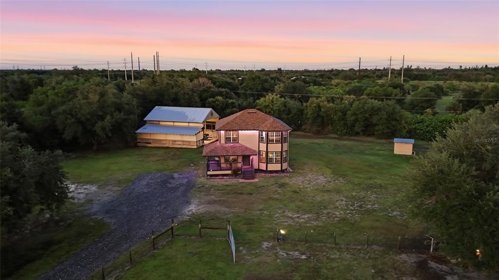 An aerial view shows a two-story house and a barn on a large grassy lot — 5780 SABAL PALM LANE, PUNTA GORDA, FL