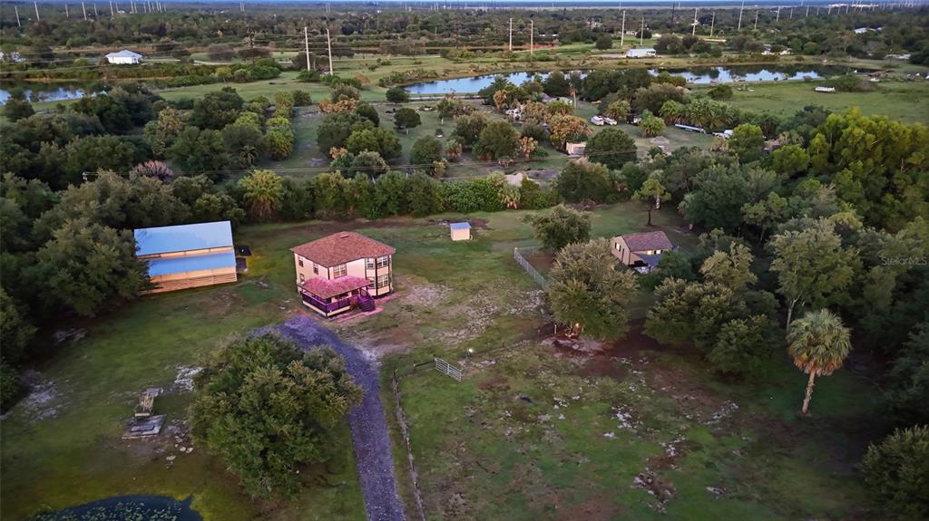 An aerial view shows a house, a barn, and a smaller building on a rural lot — 5780 SABAL PALM LANE, PUNTA GORDA, FL
