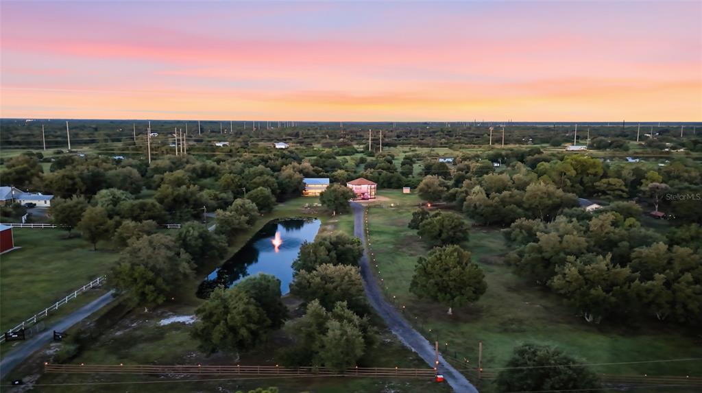 An aerial view shows a house with a pond and fountain on a rural property — 5780 SABAL PALM LANE, PUNTA GORDA, FL
