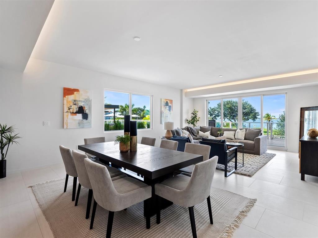 A modern kitchen features a white quartz island with bar stools and dark wood cabinetry — 1020 SUNSET POINT ROAD UNIT 103, CLEARWATER, FL