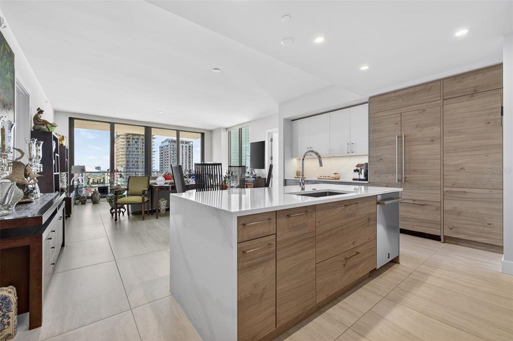 A modern kitchen features a large white quartz island, wood-grain cabinetry, and stainless steel appliances — 301 1ST STREET S UNIT 1505, ST PETERSBURG, FL