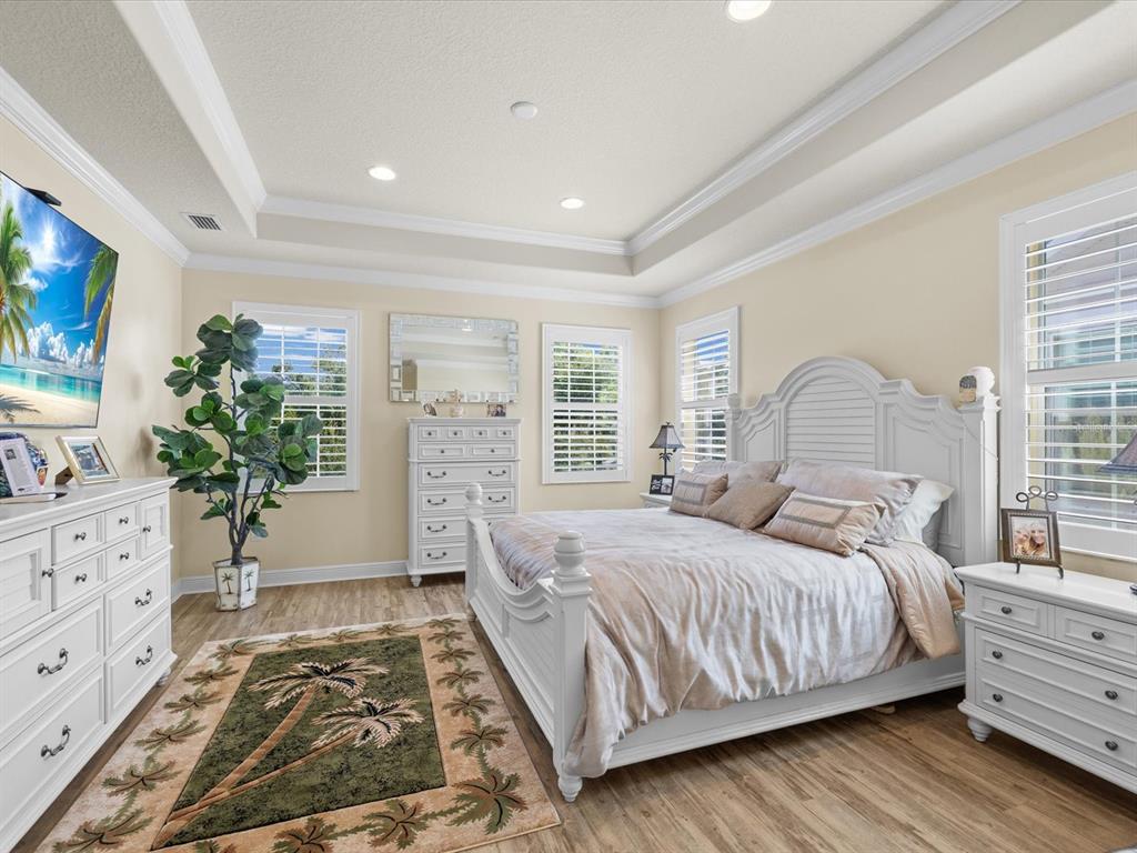 A kitchen with white cabinets, a central island with bar stools, and an adjacent dining area — 7117 PARK TREE DRIVE, TAMPA, FL