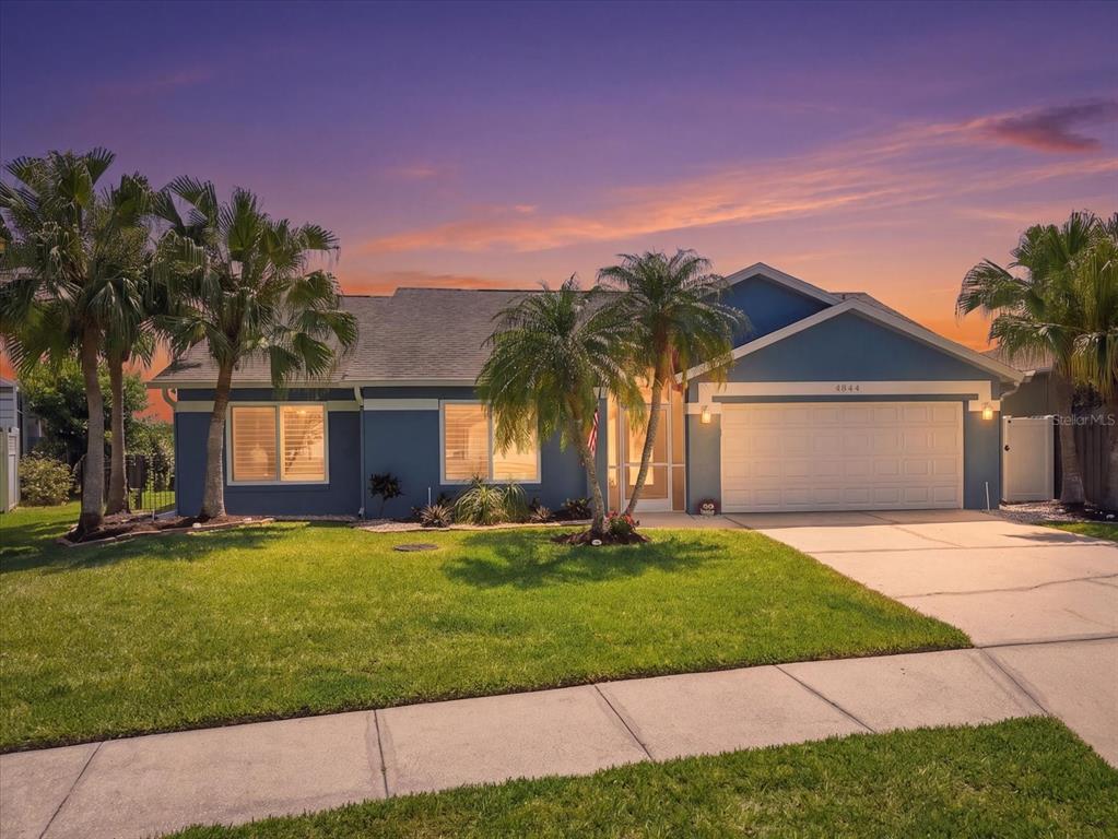 A screened-in swimming pool overlooks a canal with boat docks under a blue sky — 4844 14TH AVENUE E, BRADENTON, FL
