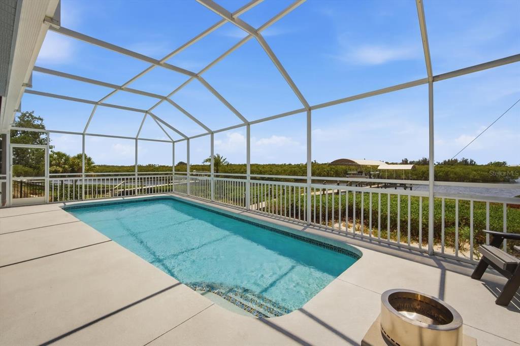A bright living room features hardwood floors, a blue patterned rug, and an open entryway — 4844 14TH AVENUE E, BRADENTON, FL