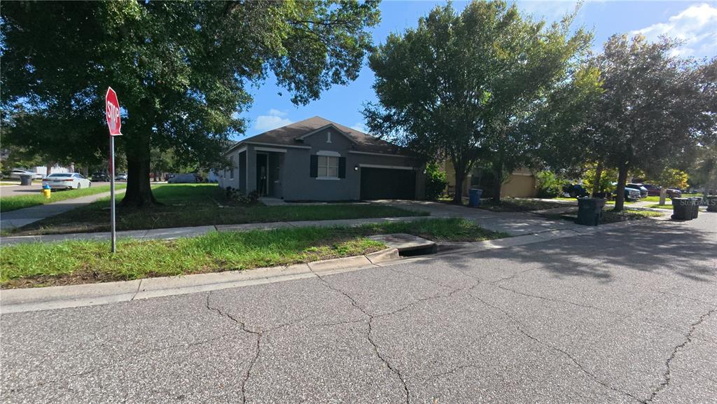 A gray single-story house with a garage and a stop sign in the front yard — 1701 CHALKSAND WAY, RUSKIN, FL