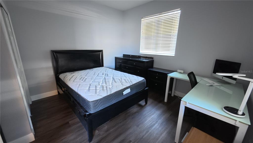 A bedroom features a black bed frame, a matching dresser, and a glass-topped desk — 1701 CHALKSAND WAY, RUSKIN, FL