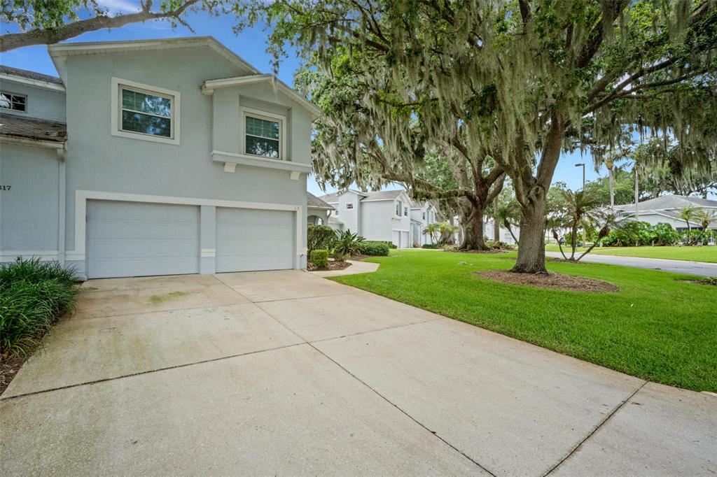 A light blue two-story house with a two-car garage and large mossy oak trees — 313 EAGLE RIDGE DRIVE UNIT 313, DAVENPORT, FL