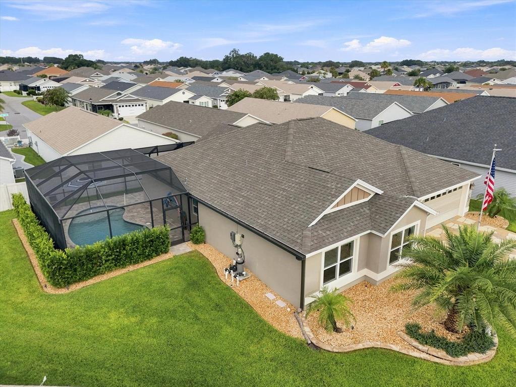 An aerial view of a suburban house with a screened-in pool and a palm tree — 6088 KECKONEN DRIVE, THE VILLAGES, FL