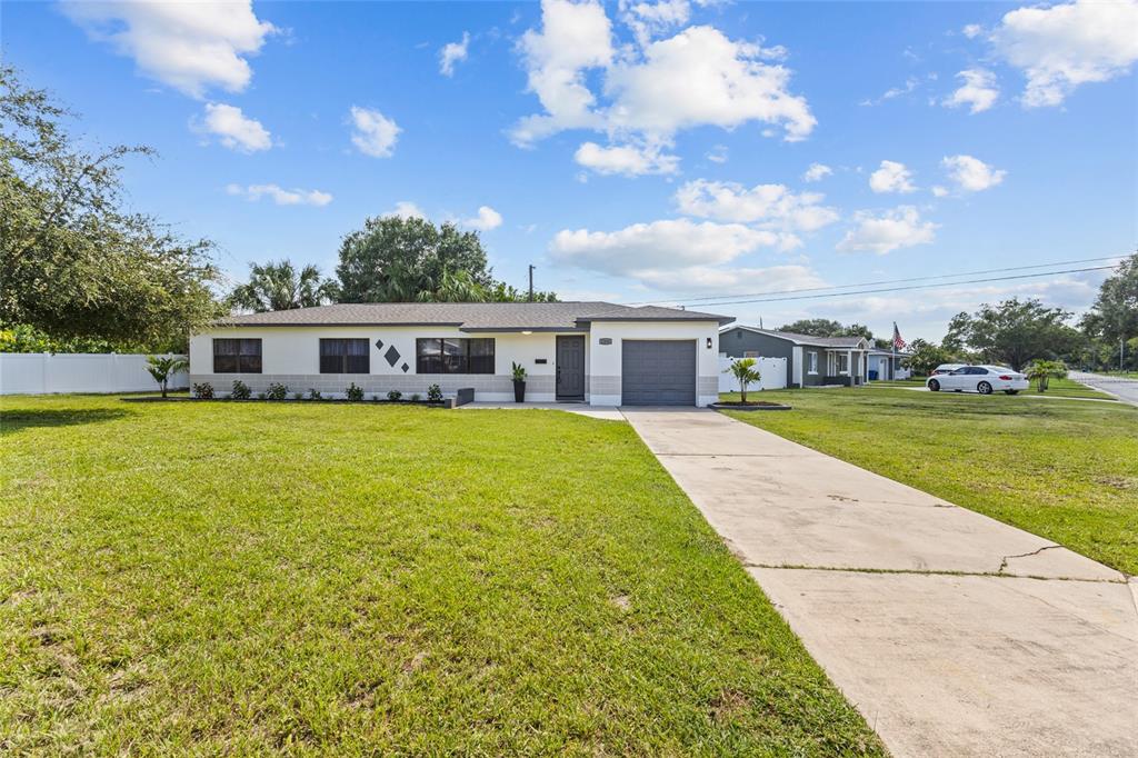 A single-story house with a white exterior, a gray garage, and a concrete driveway — 1200 63RD AVENUE N, ST PETERSBURG, FL