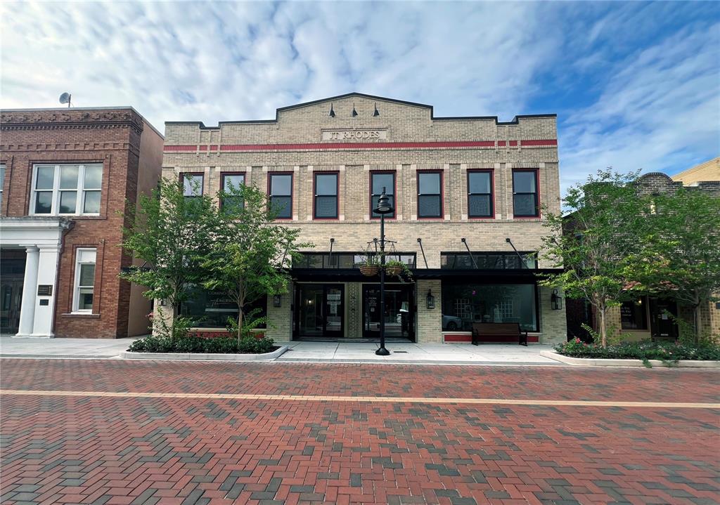 A two-story brick commercial building with a central entrance and a brick-paved street in front — 244 E PARK AVENUE, LAKE WALES, FL