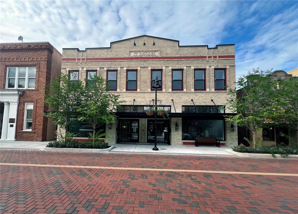 A two-story brick commercial building with a central entrance and a street-level storefront — 244 E PARK AVENUE, LAKE WALES, FL