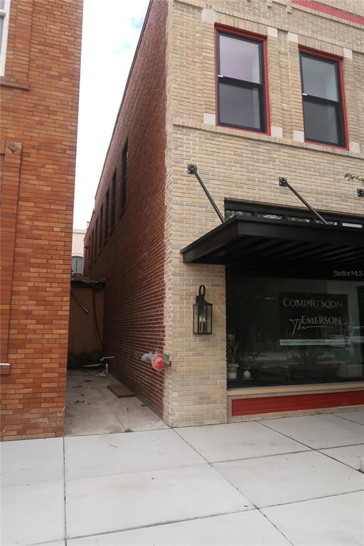 A view of a brick building exterior with a narrow alleyway and a storefront window — 244 E PARK AVENUE, LAKE WALES, FL