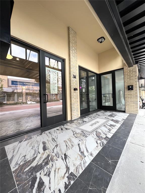 The exterior entrance features glass doors, a brick pillar, and patterned marble tile flooring — 244 E PARK AVENUE, LAKE WALES, FL
