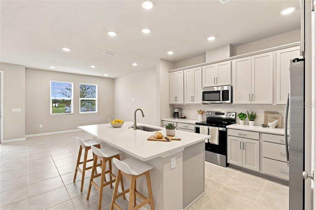 This is a floor plan of a home's first level featuring a garage, kitchen, and family room — 5592 COOPERS HAWK CT, ST CLOUD, FL