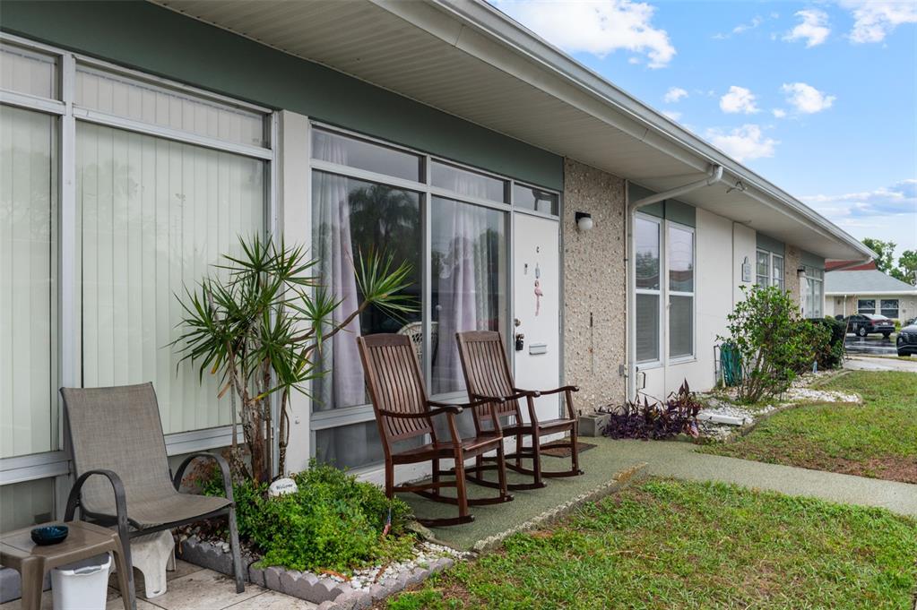 A living room and dining area with tile floors, white cabinets, and a wicker chair — 4351 TAHITIAN GARDENS CIRCLE UNIT C, HOLIDAY, FL