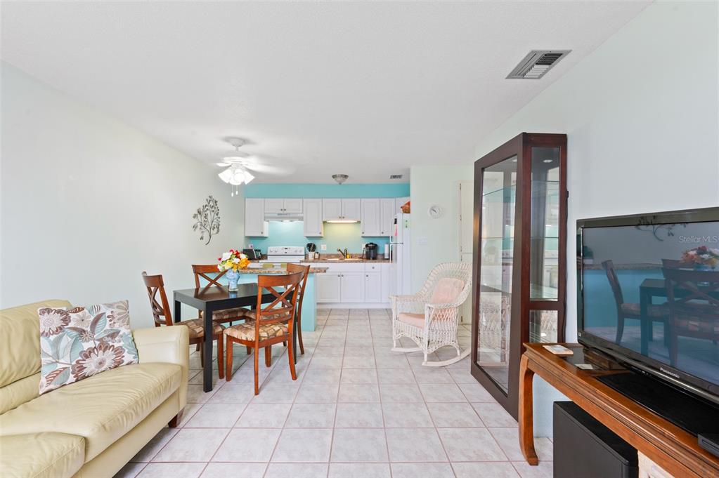 A living and dining area features tile flooring, a ceiling fan, and a glass door — 4351 TAHITIAN GARDENS CIRCLE UNIT C, HOLIDAY, FL