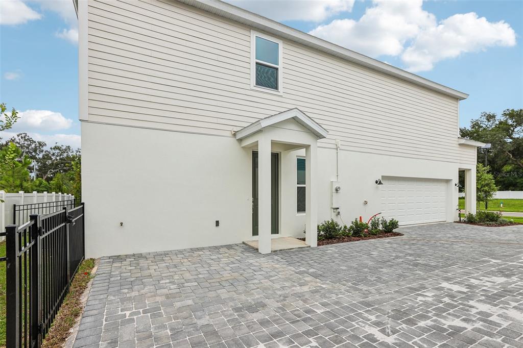 A blue front door is set within a covered porch featuring white pillars and stone accents — 607 SILVER STREAM COURT, BRANDON, FL
