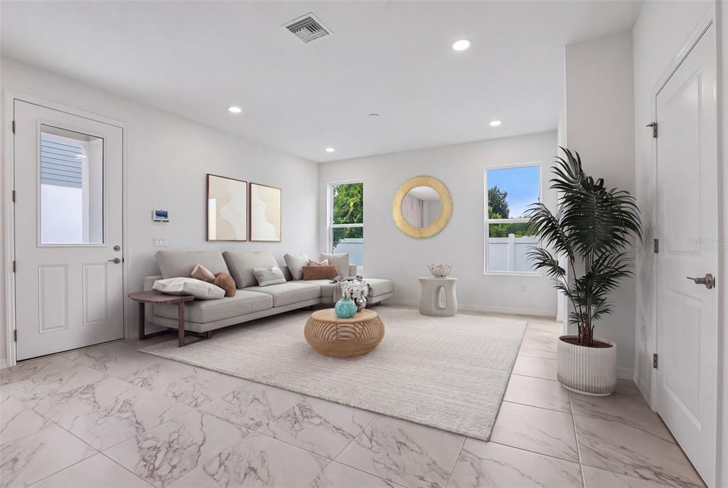 A white kitchen with an island, marble-look tile floors, and a staircase on the left — 607 SILVER STREAM COURT, BRANDON, FL