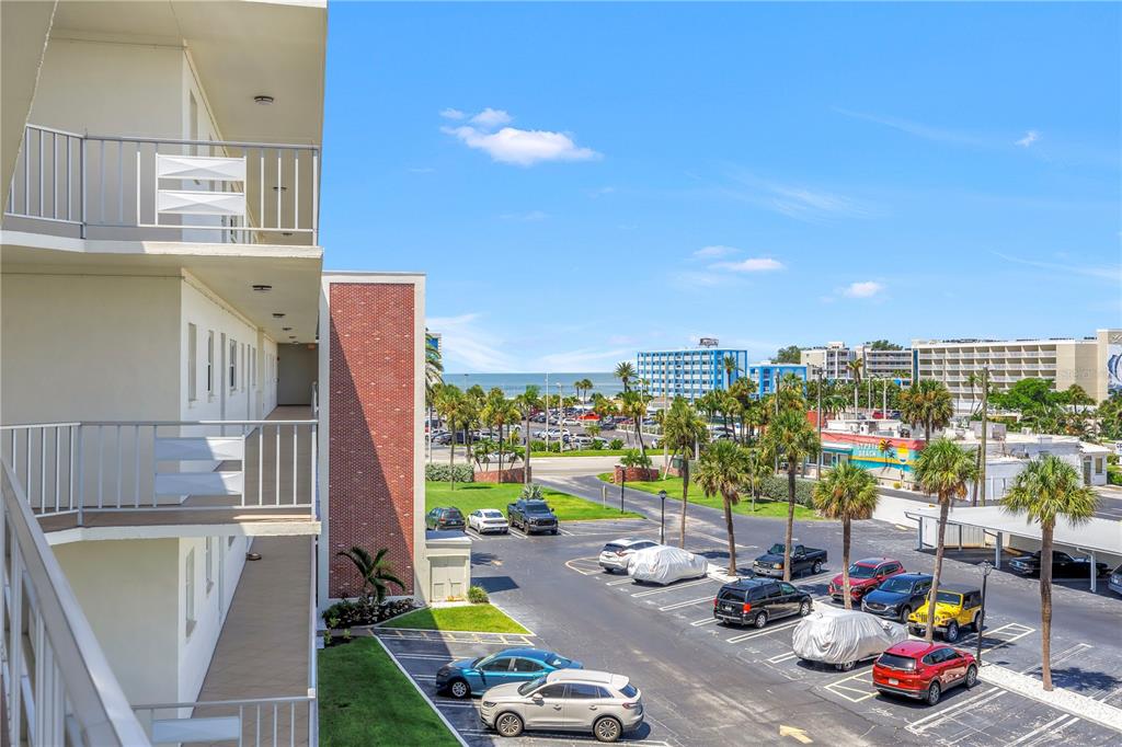 An elevated view of a parking lot and palm trees near a beach — 5575 GULF BOULEVARD UNIT 426, ST PETE BEACH, FL