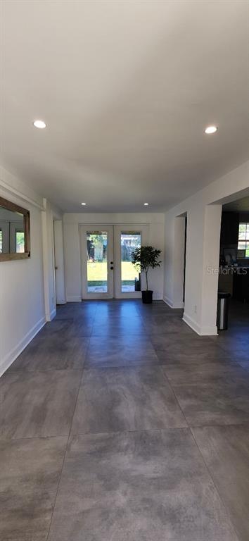 A room with large gray floor tiles, recessed lighting, and glass doors leading outside — 146 MARSELLA ROAD, DEBARY, FL