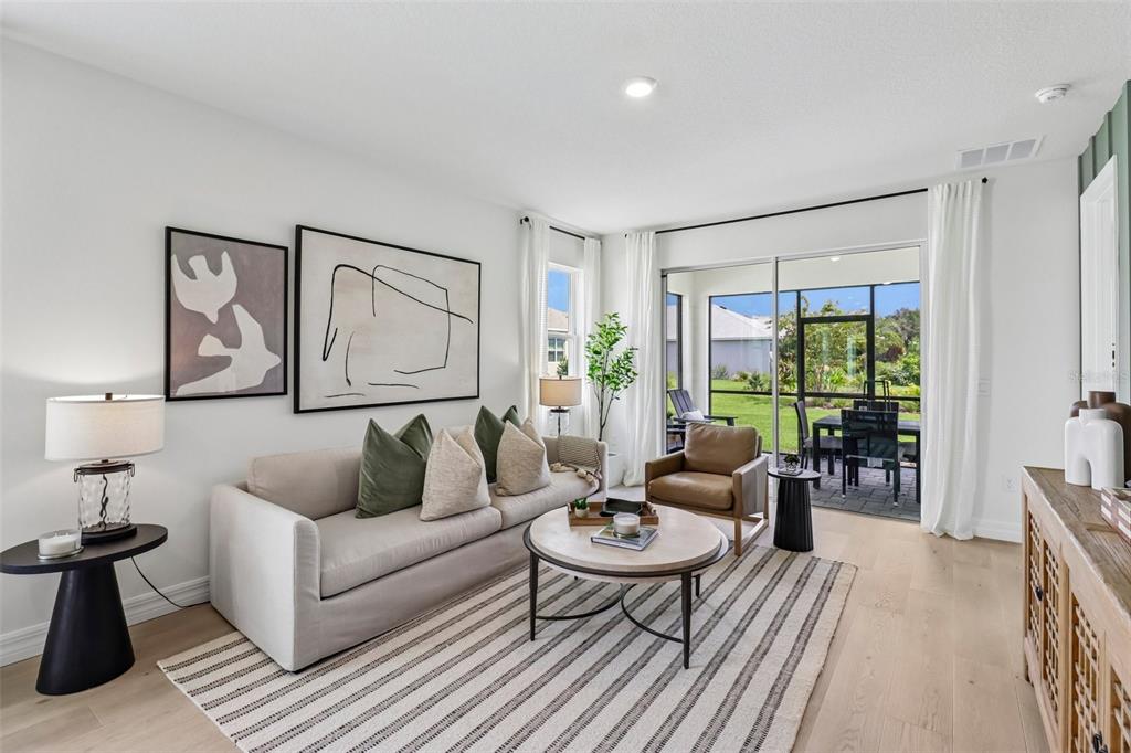 A living room features a sofa, coffee table, armchair, and sliding doors opening to a patio — 3945 KENNEBUNK LOOP, MOUNT DORA, FL