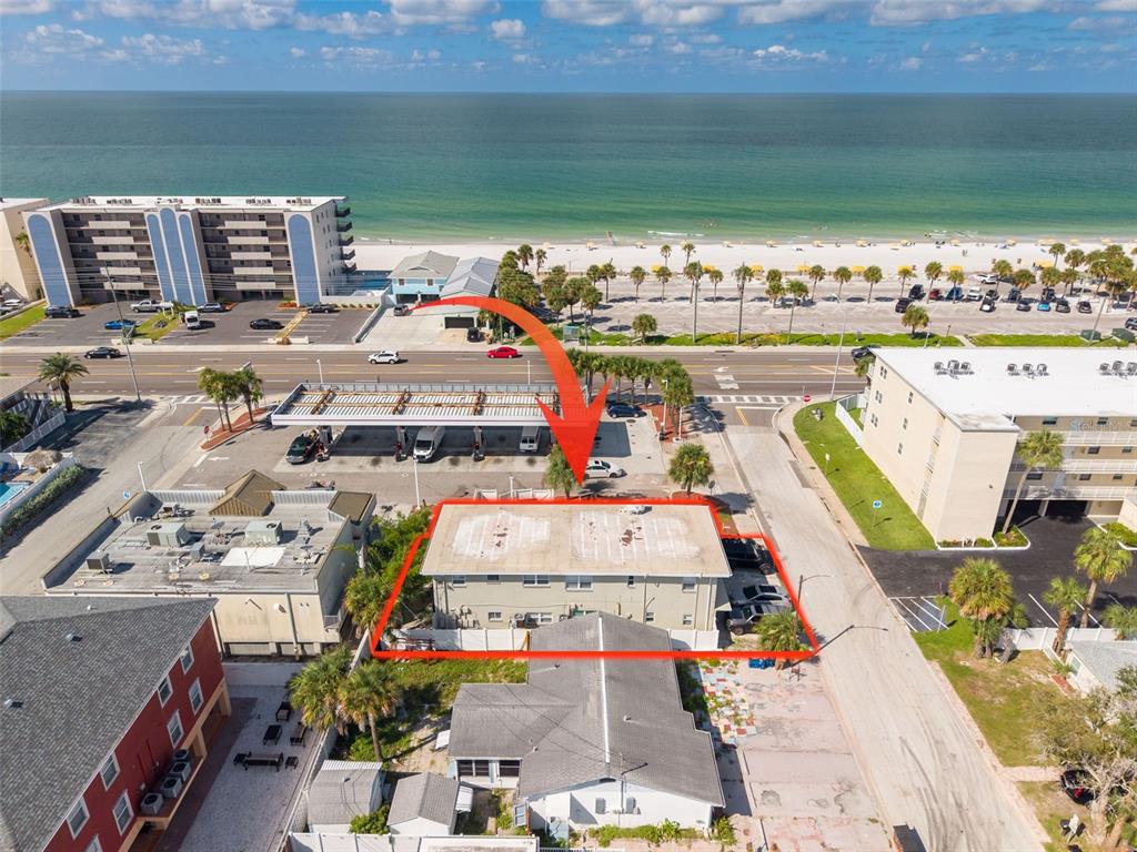 An aerial view shows a two-story apartment building outlined in red near a beach — 37 144TH AVENUE, MADEIRA BEACH, FL