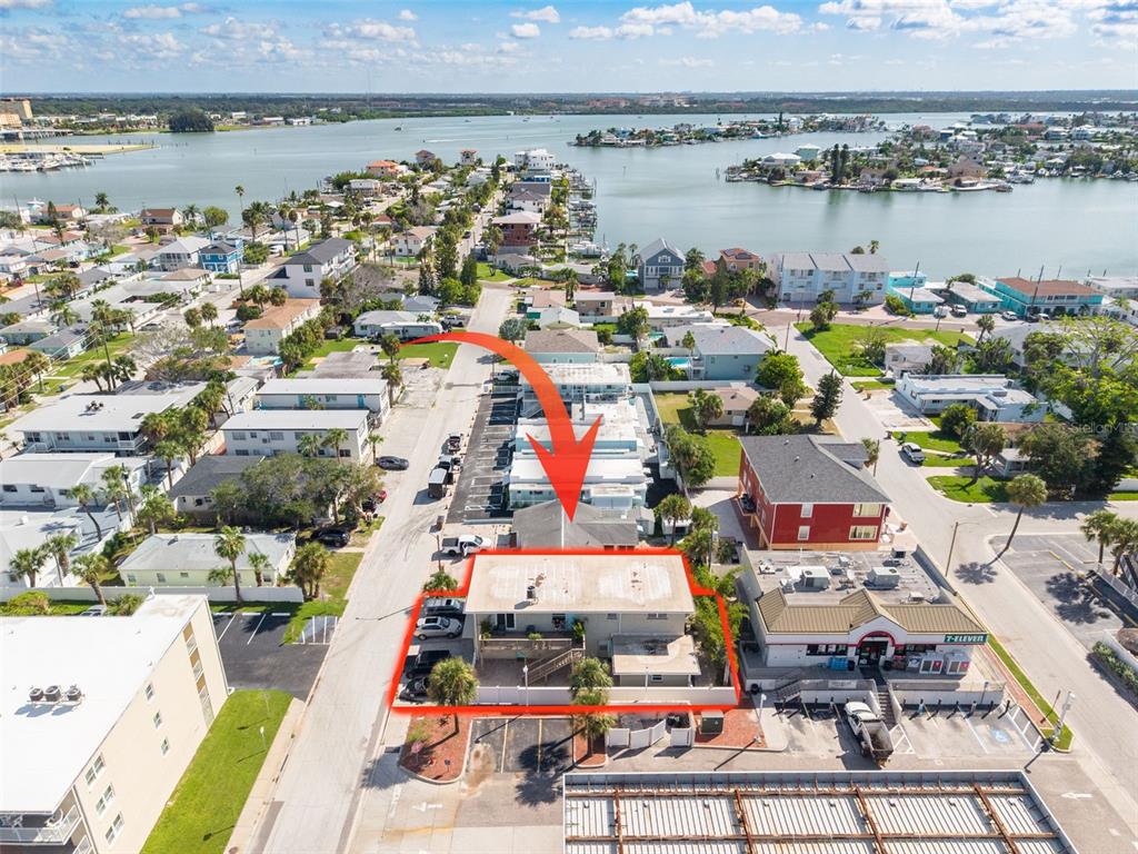 An aerial view shows a two-story building outlined in red near a 7-Eleven store — 37 144TH AVENUE, MADEIRA BEACH, FL