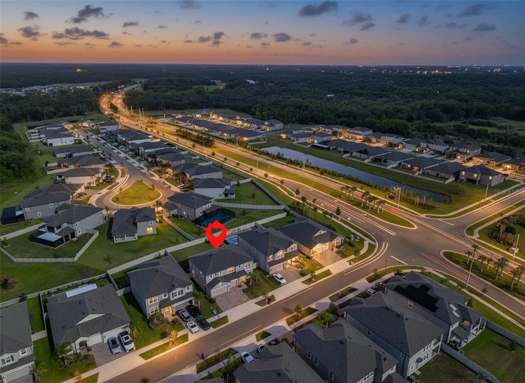 A two-story suburban house with a gray exterior, two garage doors, and a paved driveway — 2927 MARINE GRASS DRIVE, WIMAUMA, FL