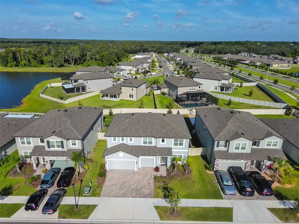 A kitchen features dark wood cabinets, granite countertops, a large island, and four gray stools — 2927 MARINE GRASS DRIVE, WIMAUMA, FL